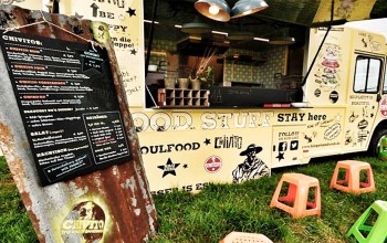 Foodtruck Chivito auf Wiese mit Sitzhockern und Speisekarte