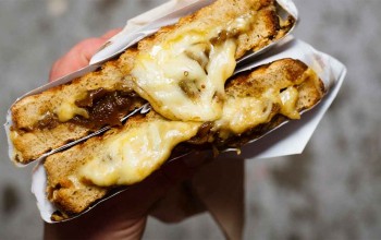 aufgeschnittenes Grilled Cheese Sandwicht herauslaufender Käse