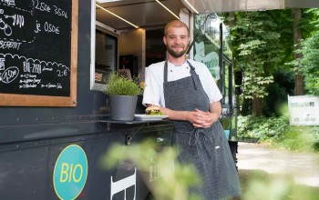 Arne Ulfers an Theke Foodtruck gelehnt