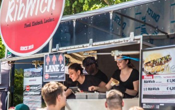 Mitarbeiter reichen Sandwiches aus dem Foodtruck Ribwich