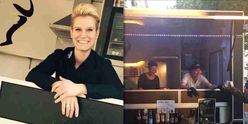 Strahlend lachende Frau und Burger aus Foodtruck Köln herausgebend