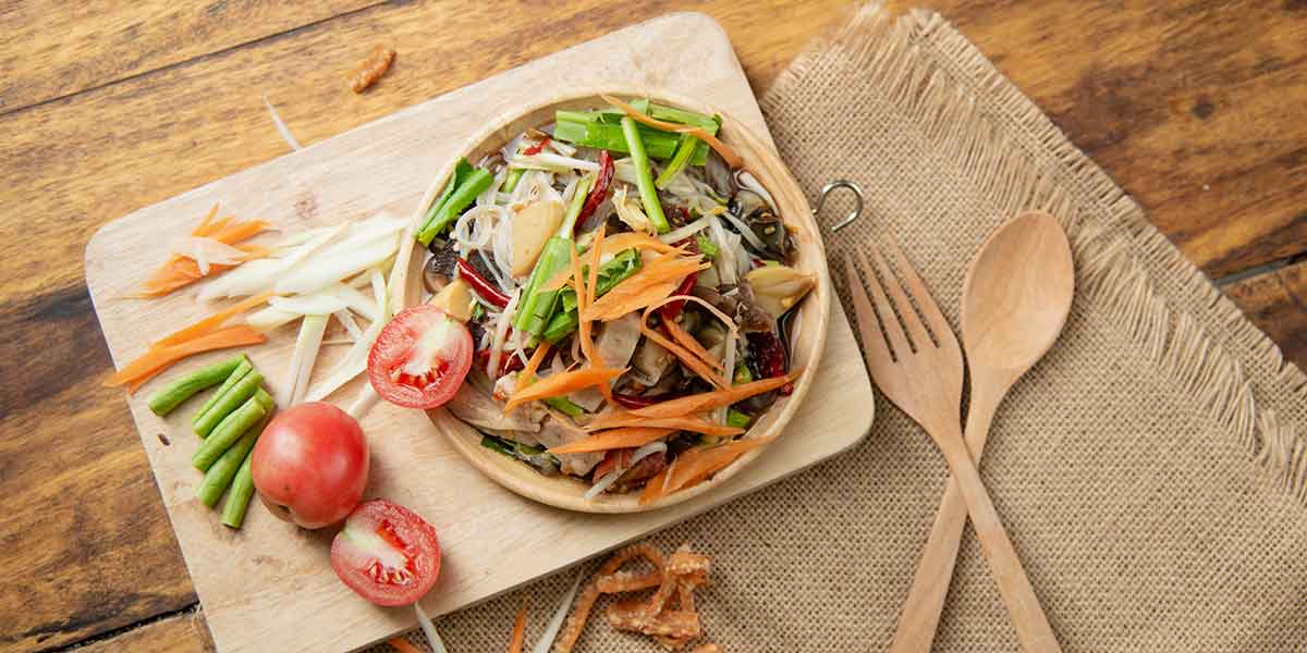 Som Tam ist ein scharfes Papaya-Salatgericht, das hauptsächlich aus gestoßenem Gemüse besteht.